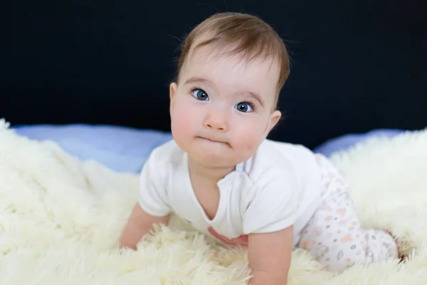 Vackra blå eyed lilla bebis på sängen — Stockfoto