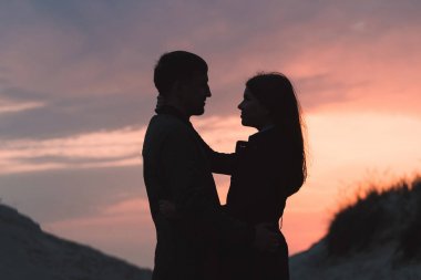 genç bir çift deniz kenarında batımında sonbahar yakın çekim sarılma