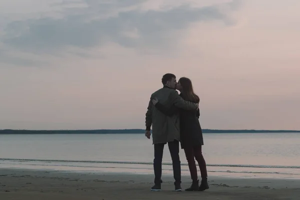 Jovem casal amoroso beijando na praia no outono . — Fotografia de Stock