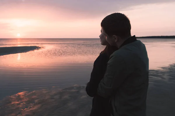 若いカップルの秋の海で夕日を眺めを愛する. — ストック写真
