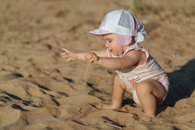 Küçük çocuk sahilde oynuyor.