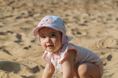 Küçük çocuk sahilde oynuyor.