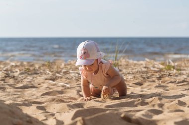 Küçük çocuk sahilde oynuyor.