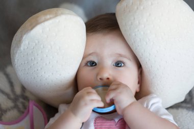 Küçük bebek elinde kapaklı bir boyun yastığı yalan