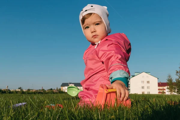 Small child playing sitting on a lawn in autumn. — Stock Photo, Image