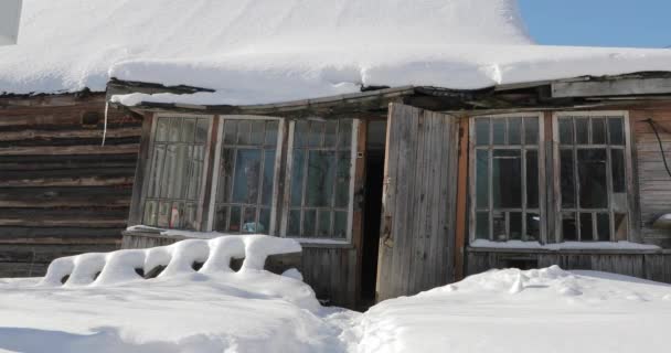 Vieja casa de madera abandonada bajo la nieve — Vídeo de stock