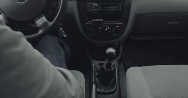 Άτομο παίρνει στο αυτοκίνητο, αρχίζει μια μηχανή και ενεργοποιεί την — Αρχείο Βίντεο