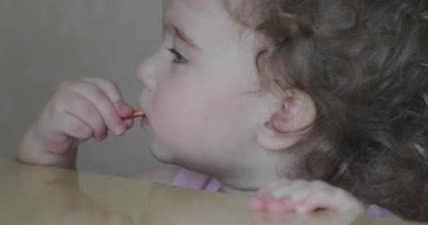 Pequena menina encaracolado comer palhas padaria — Vídeo de Stock