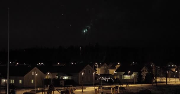 Πυροτεχνήματα στον ουρανό νύχτας πάνω από τα σπίτια — Αρχείο Βίντεο