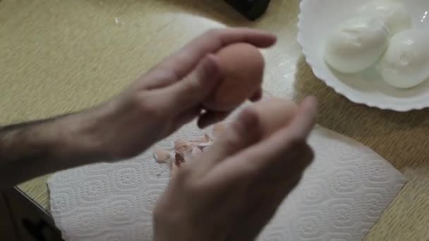 Hombre limpia un huevo de gallina hervido de la cáscara — Vídeo de stock