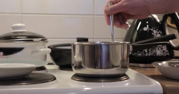 Matlagning en gröt under omrörning med en sked — Stockvideo