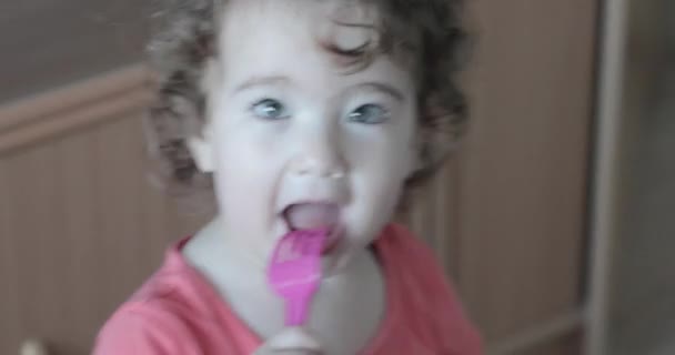 Petit enfant avec une fourchette de bébé dans sa bouche — Video