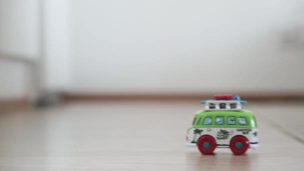 Childrens toy car minibus rides the floor. Slow motion video — Stock Video