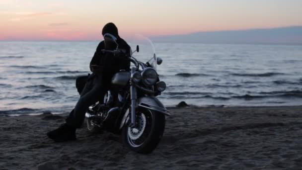 Biker motocyklista na břehu oceánu v večer — Stock video