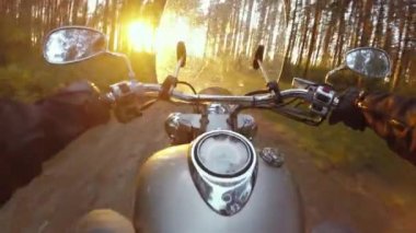 Ağaçların üzerinden bir motosiklet binme