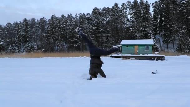 Άντρας γυρίζει στο κεφάλι του στην επιφάνεια του μια παγωμένη λίμνη για ένα χειμωνιάτικο απόγευμα. Βίντεο αργής κίνησης — Αρχείο Βίντεο