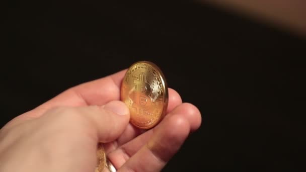 Bitcoin goud in de glans van de hand. Slow-motion video — Stockvideo