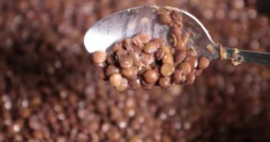 Mercimek bir tavada kavurma yakın çekim. bir kaşıkla karıştırarak