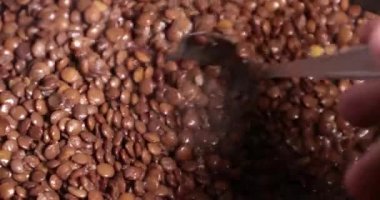 Mercimek bir tavada kavurma yakın çekim. bir kaşıkla karıştırarak