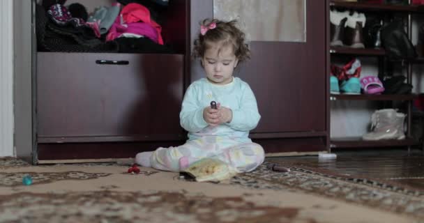 Bambina sta giocando con il rossetto a casa sul pavimento — Video Stock