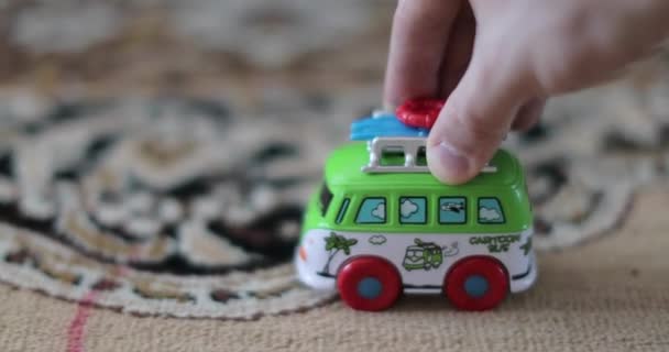 Παιδική παιχνίδι λεωφορείο βόλτες στον τάπητα στο σπίτι — Αρχείο Βίντεο