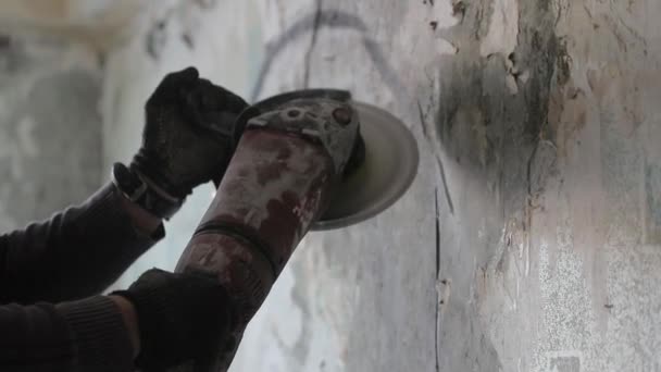 Hombre sierra una pared de hormigón con una amoladora angular. Vídeo en cámara lenta — Vídeos de Stock