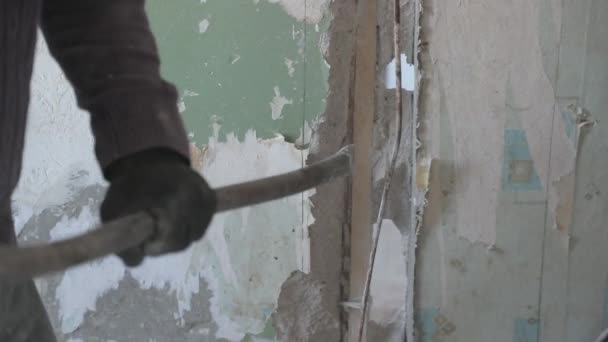 Рабочий ломает бетонную стену большим металлическим ломом — стоковое видео