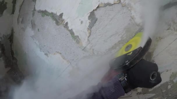Uomo sega un muro di cemento con una smerigliatrice angolare. vista in prima persona — Video Stock