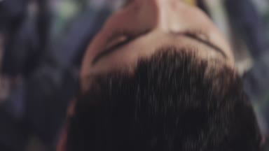 bir kıl olan genç adam kafasını arkaya doğru yatırır ve dışarı duman sağlar