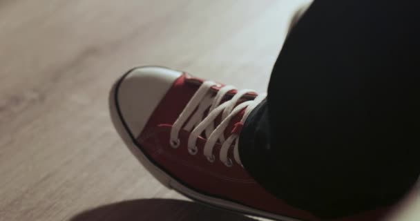 Человеческая нога в красных кроссовках бьет ритм — стоковое видео