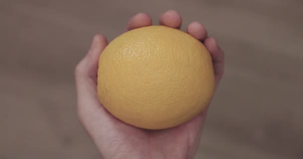 Χέρι κρατά ένα πορτοκαλί κάτοψη — Αρχείο Βίντεο