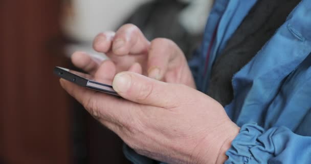 Handen van een oude man een smartphone gebruiken — Stockvideo