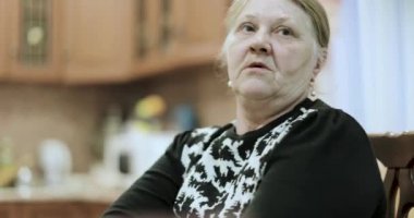 eski büyükanne masada oturan hikayeler anlatır