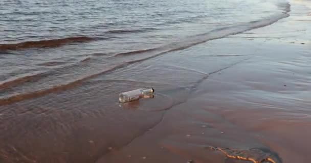 Leere Glasflasche spült die Wellen des Meeres am Abend — Stockvideo