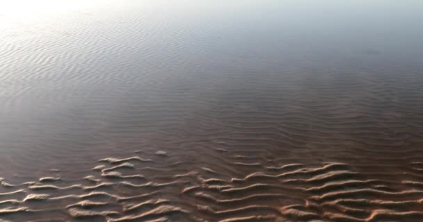 El agua fluye a través de la arena dejando hermosos patrones — Vídeos de Stock