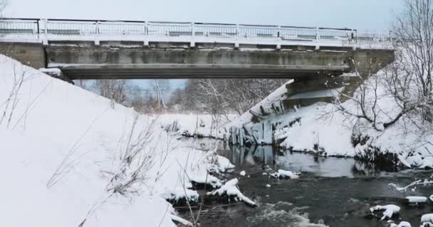 La primavera y el río fluyen a lo largo de las orillas nevadas — Vídeo de stock