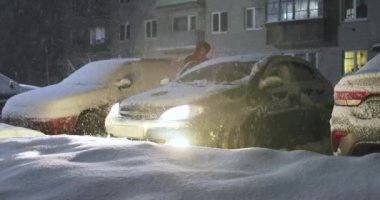 adam ısıtır ve kar arabasından temizler