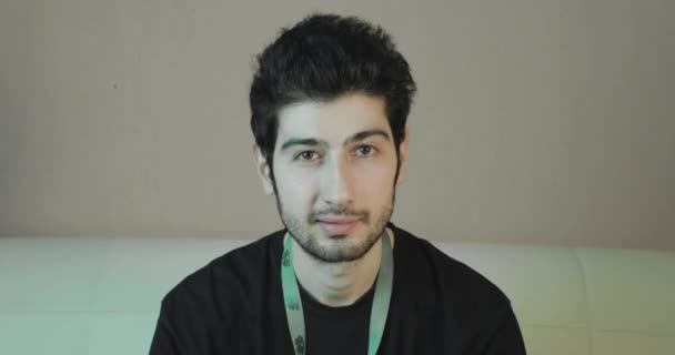 Junger hübscher Kerl mit einem Bart im Gespräch — Stockvideo