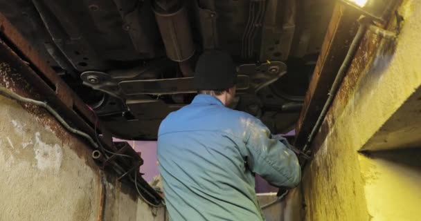 Mechanic repareert de auto uit de onderstaande lijst — Stockvideo