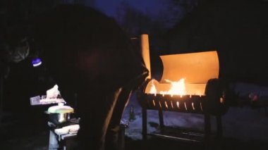 bir adam mangal geceleri başka bir parlar onun el feneri ile aşçılar