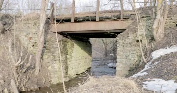 Movimiento del río bajo un puente de piedra en primavera — Vídeo de stock