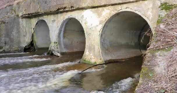 Movement of the river in spring through special large pipes on the street — Stock Video