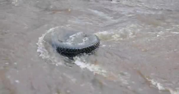 Волны реки промывают шину машины — стоковое видео