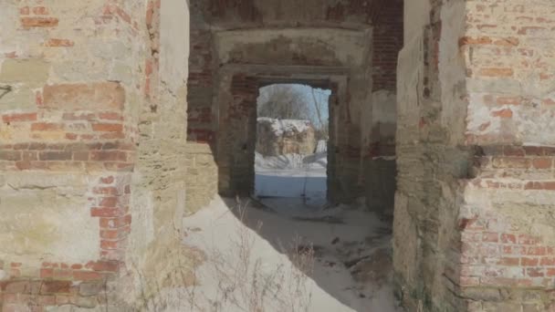 caméra avance et explore les ruines d'un vieux bâtiment en brique rouge en hiver. Vidéo POV 4k 
