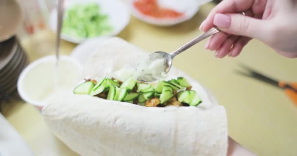 Mâinile țin pâine pita și pun ingredientele pentru shawarma — Videoclip de stoc