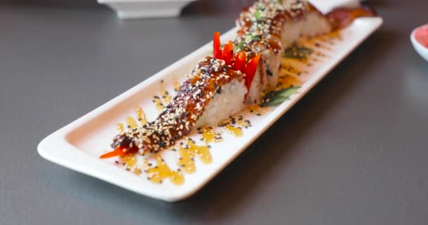 Comida japonesa de arroz en un plato largo blanco — Vídeo de stock