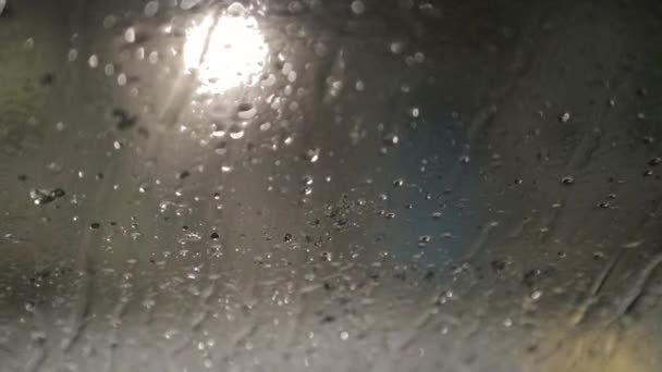 V noci sníh padá na skle a taje — Stock video