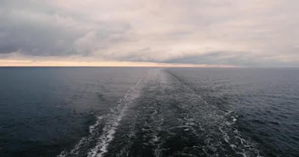 Elegante estela indignada racha de agua que queda detrás de la popa de un barco en marcha. Mar Báltico en clima nublado . — Vídeo de stock