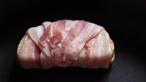 One slice of a loaf wrapped in salami — Stock Photo, Image