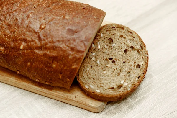 Svart bakade bröd och en skivad bit — Stockfoto